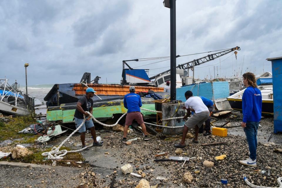 <p>Fishermen attempt to salvage a damaged fishing boat after the passage of Hurricane Beryl at the Bridgetown Fish Market, Bridgetown, Barbados</p> (AFP via Getty Images)