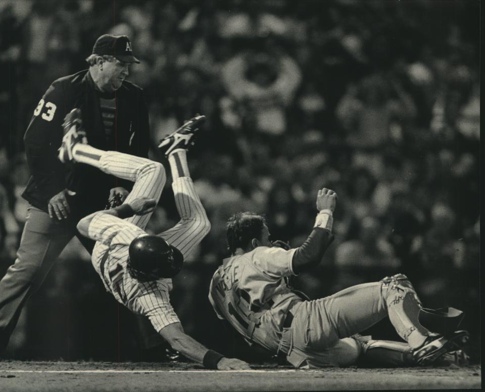 Robin Yount flipped over Seattle catcher Dave Valle trying to score on a double steal May 9, 1987.  Home plate umpire Durwood Merrill (left) called Yount out on the play.