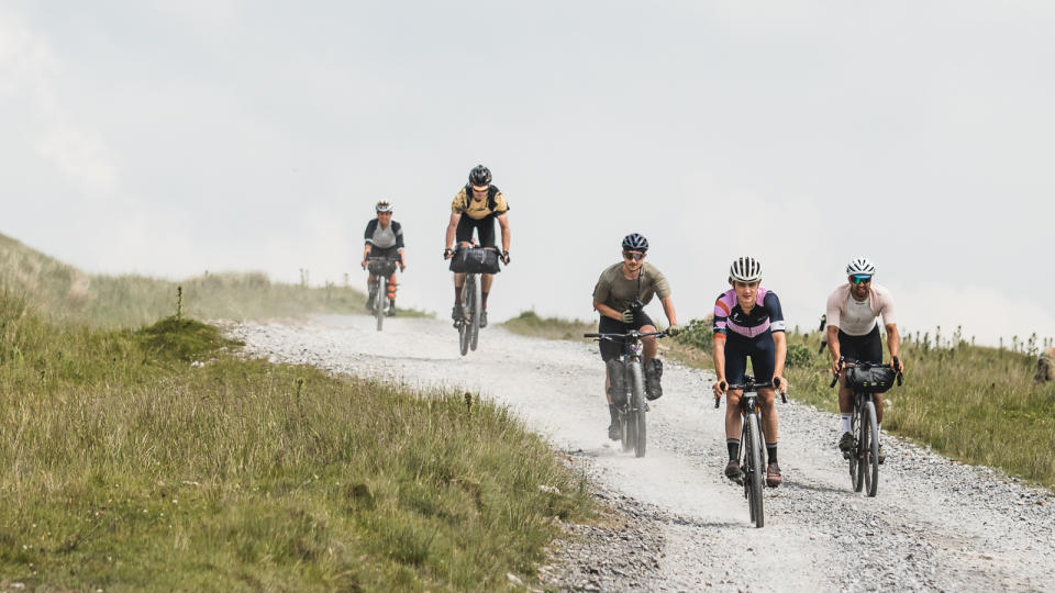  A group of riders descending together on a gravel road 