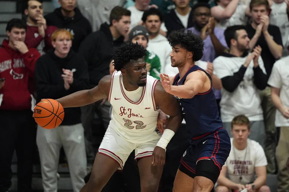 Saint Joseph's Christ Essandoko, left, tries to get past Dayton's Nate Santos during the first half of an NCAA college basketball game, Tuesday, Feb. 6, 2024, in Philadelphia. (AP Photo/Matt Slocum)