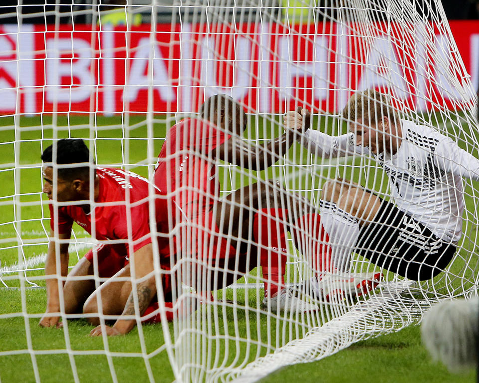 Germ any's Timo Werner, right, and two Peru players are caught in the net during a friendly soccer match between Germany and Peru in Sinsheim, Germany, Sunday, Sept. 9, 2018. (AP Photo/Michael Probst)