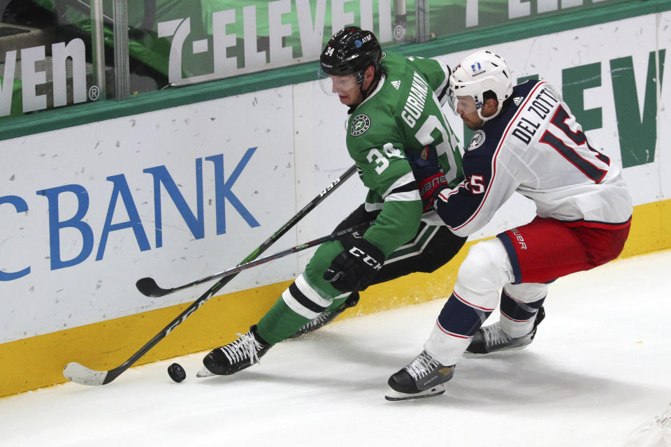 Dallas Stars right wing Denis Gurianov (34) and Columbus Blue Jackets defenseman Michael Del Zotto (15) battle for the puck int he second period during an NHL hockey game on Thursday, April 15, 2021, in Dallas. (AP Photo/Richard W. Rodriguez)