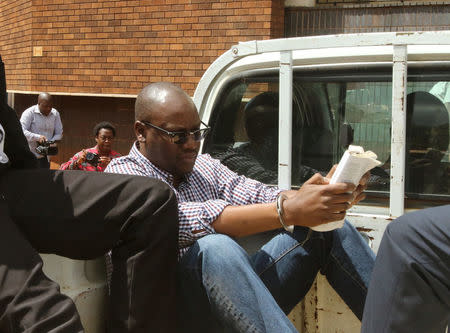 Zimbabwean pastor Evan Mawarire reads a bible as he arrives at the Harare Magistrates court in Harare, Zimbabwe, February 3, 2017.REUTERS/Philimon Bulawayo