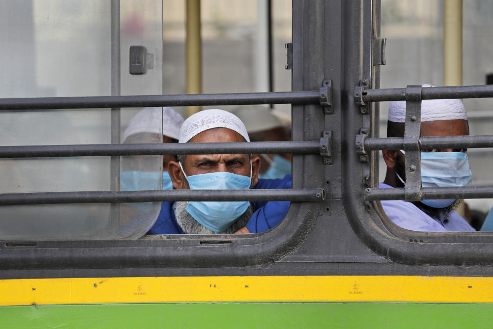 FILE - In this March 31, 2020, file photo, Muslim pilgrims wait in bus that will take them to a quarantine facility, after a government raid discovered the largest viral cluster in India at the Nizamuddin area of New Delhi, India. Muslims in India are being stigmatized after the government blamed an Islamic missionary meeting for a surge in coronavirus cases. Experts who have studied previous epidemics warn that the stigma could hamper efforts to stop the contagion and prevent many from getting themselves tested. (AP Photo/Manish Swarup, File)
