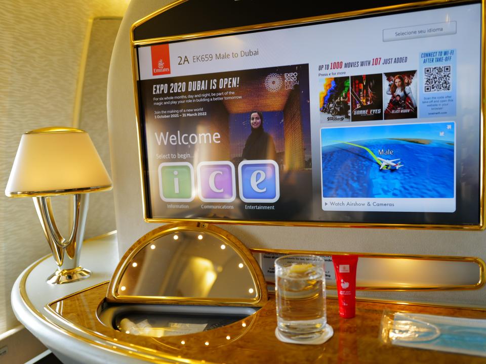 Table with lamp, TV, and glass of water on airplane