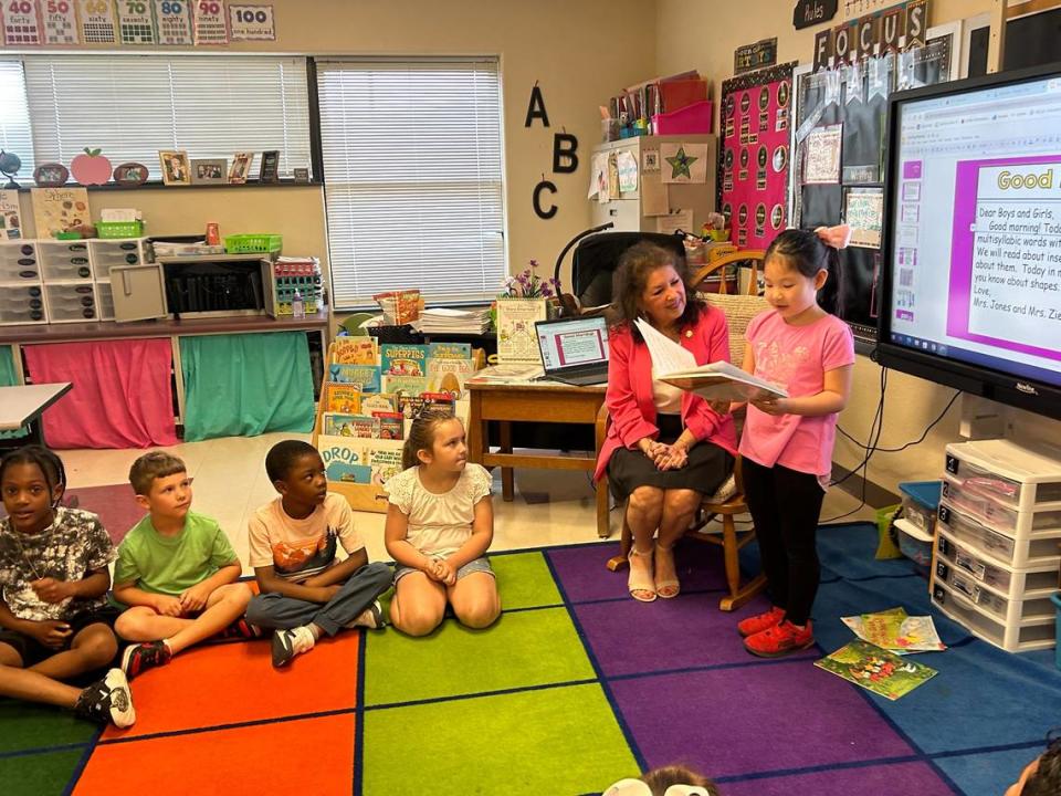 State Rep. Donna White watches as Christine Duan reads her weekend journal to her first-grade classmates at Riverwood Elementary School in Clayton, N.C., on May 15, 2023. It was a statewide Bring Your Legislator To School Day.