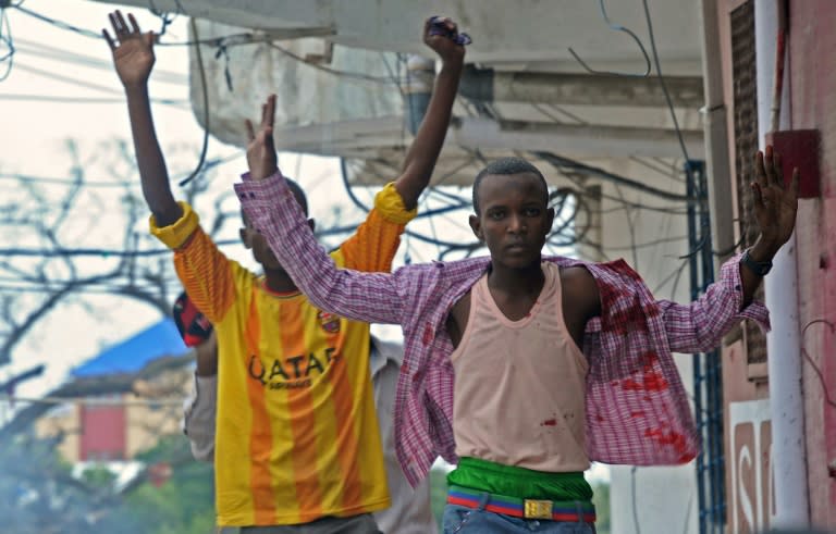 A man covered with blood runs away from the scene of a car bomb attack claimed on the Naasa Hablood hotel in Mogadishu on June 25, 2016