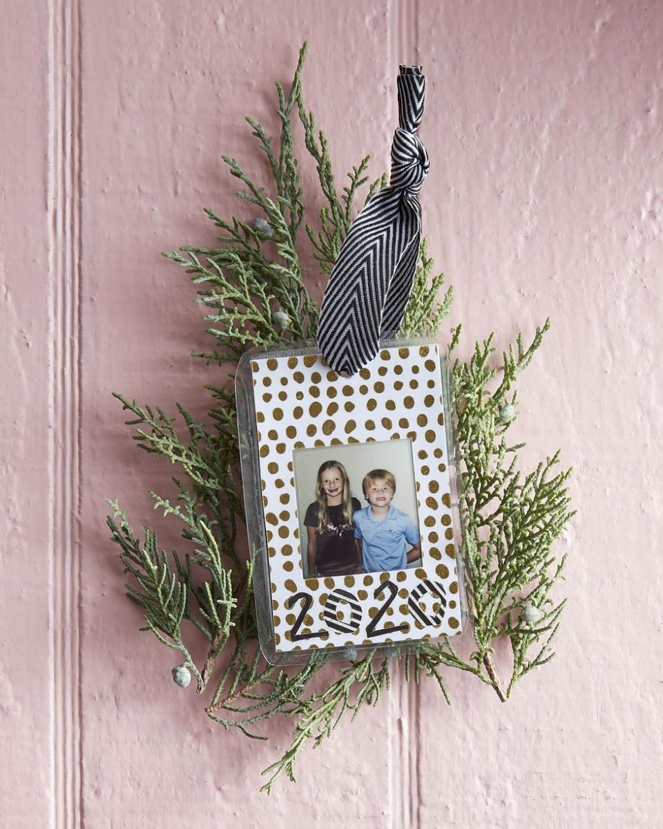 laminated picture of two children with 2020 under it, surrounded by christmas greenery