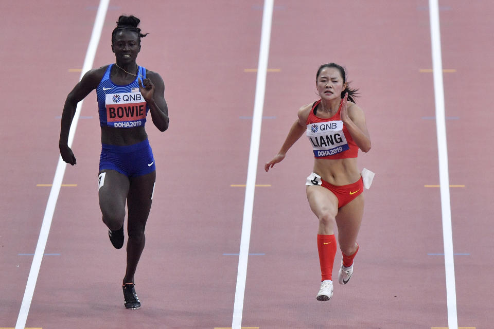 Tori Bowie, of the United States, and Xiaojing Liang, of China, right, compete in a women's 100 meter race heat during the World Athletics Championships in Doha, Qatar, Saturday, Sept. 28, 2019. (AP Photo/Martin Meissner)