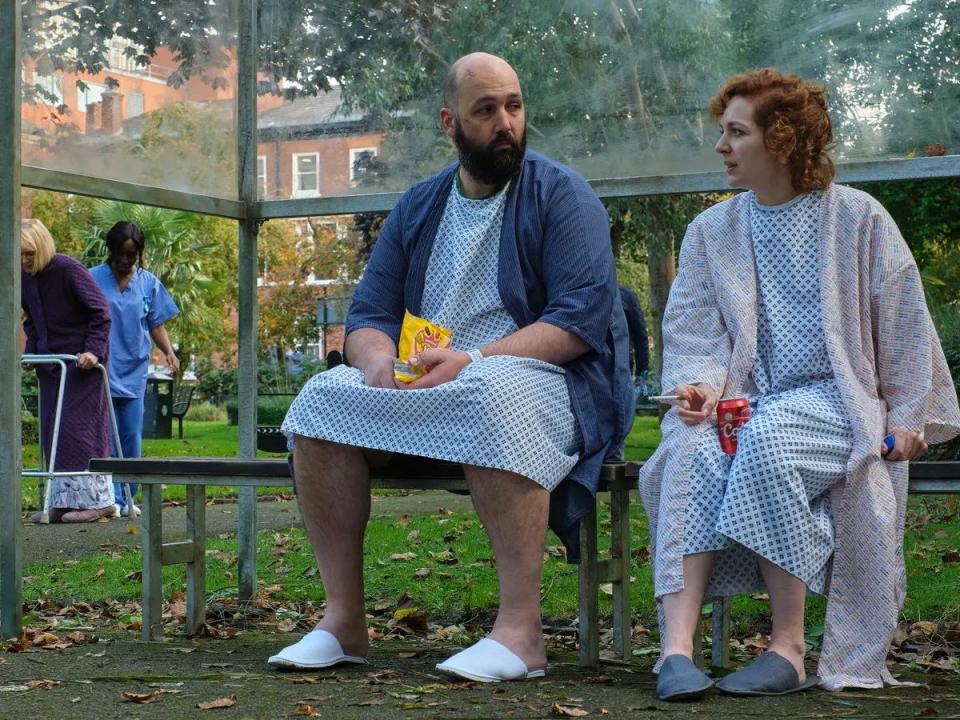 significant other, katherine parkinson and youssef kerkour sit on a bench outside