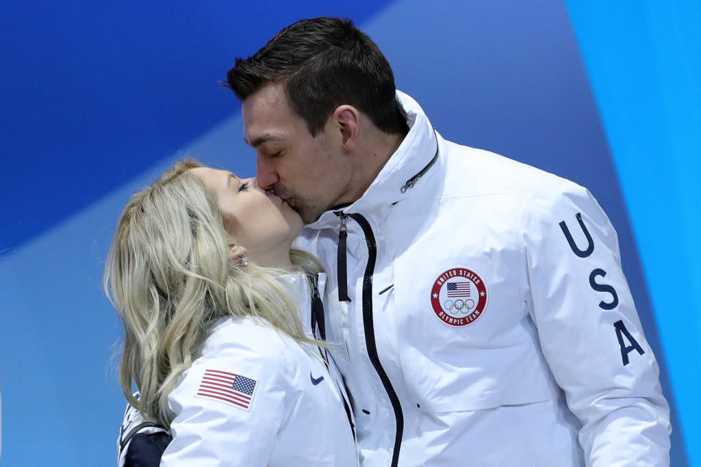 Alexa Scimeca Knierim (left) and Chris Knierim kiss after receiving bronze medals in the team figure-skating event. (Getty)