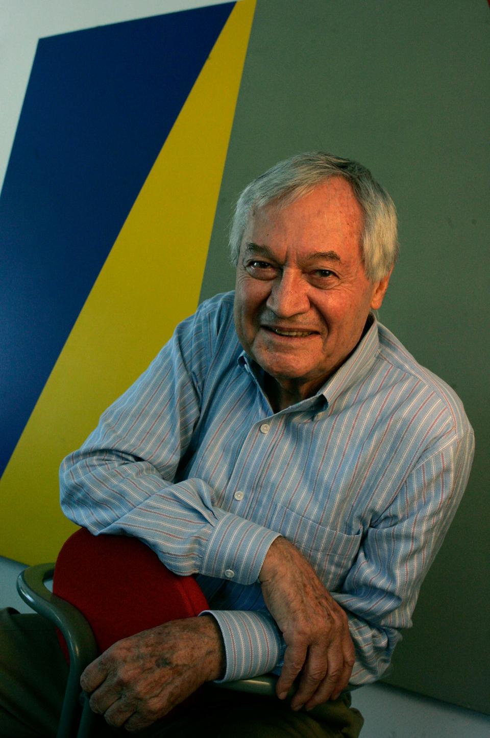 Roger Corman leaning on a red chair