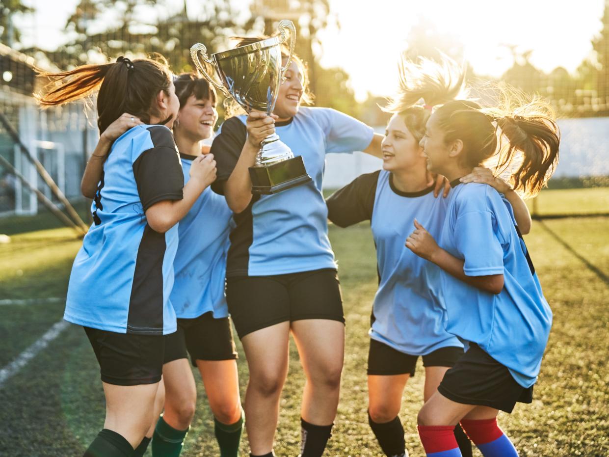 A stock photo of a girl's soccer team celebrating after a win.