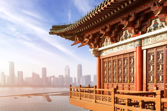 Close-up shot on the corner of a traditional Chinese building with a modern skyscraper skyline in the background.