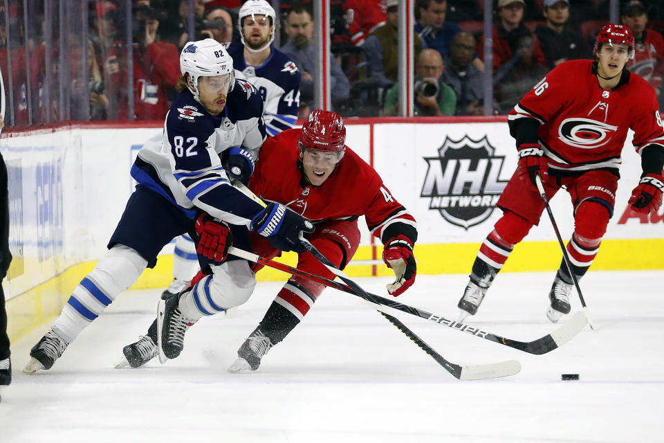 Winnipeg Jets' Mason Appleton (82) battles for the puck with Carolina Hurricanes' Haydn Fleury (4) during the first period of an NHL hockey game in Raleigh, N.C., Tuesday, Jan. 21, 2020. (AP Photo/Karl B DeBlaker)