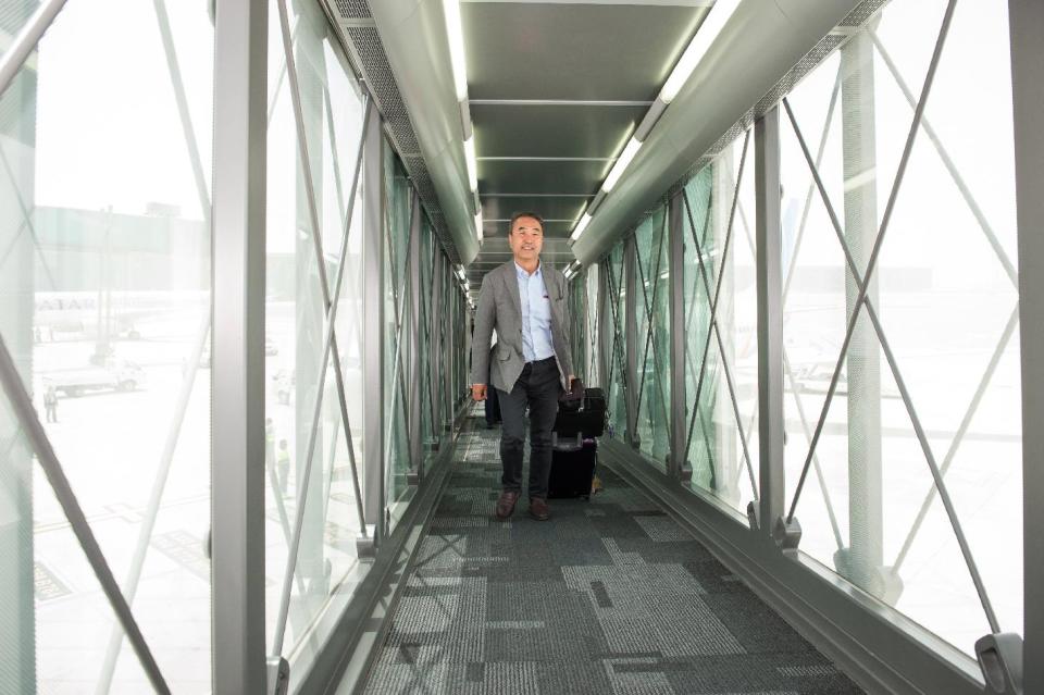 In this undated handout photo provided by The New Hamad International Airport on Wednesday, April 30, 2014, the first passenger arrives to board a Qatar Airways plane in Doha, Qatar, on Wednesday, April 30, 2014. A massive new airport in the Qatari capital has started handling its first commercial flights after years of delays as the natural-gas rich Gulf nation works to transform itself into a major aviation hub. (AP Photo/HIA)