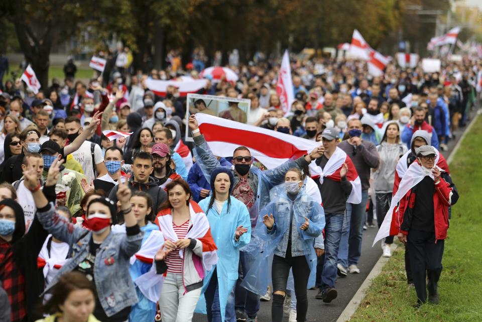 People with old Belarusian national flags march during an opposition rally to protest the official presidential election results in Minsk, Belarus, Sunday, Sept. 27, 2020.Hundreds of thousands of Belarusians have been protesting daily since the Aug. 9 presidential election. (AP Photo/TUT.by)