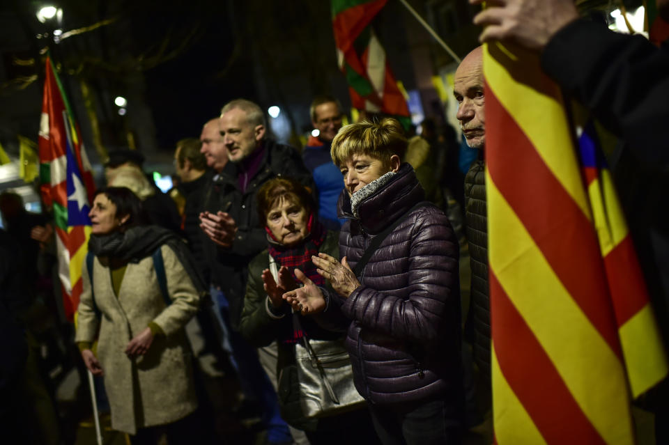 Pro independence Basque demonstrators gather along flags of the Basque Country or 'Ikurrina' and pro independence Catalonia flag, in support of Catalonian separatist politicians in the small basque village of Hernani, northern Spain, Tuesday, Feb. 12, 2019. Spain is bracing for the nation's most sensitive trial in four decades of democracy this week, with a dozen Catalan separatists facing charges including rebellion over a failed secession bid in 2017. (AP Photo/Alvaro Barrientos)