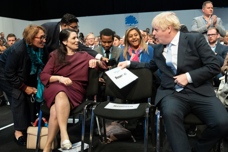 <p>Prime Minister Boris Johnson chats with Home Secretary Priti Patel while they wait for Chancellor of the Exchequer, Rishi Sunak to deliver his keynote speech to the Conservative Party Conference in Manchester. Picture date: Monday October 4, 2021.</p>
