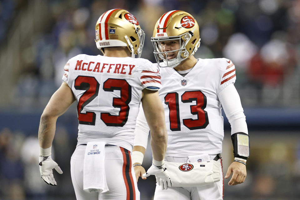 SEATTLE, WASHINGTON - DECEMBER 15: Christian McCaffrey #23 and Brock Purdy #13 of the San Francisco 49ers celebrate a touchdown  during the third quarter against the Seattle Seahawks at Lumen Field on December 15, 2022 in Seattle, Washington. (Photo by Steph Chambers/Getty Images)