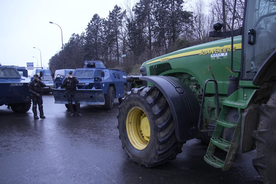 Gendarmes y vehículos blindados enfrentan a tractores en una autopista cortada el jueves 1 de febrero de 2024 en Chilly-Mazarin, en el sur de París. Los granjeros bloquearon más carreteras en Bélgica, Francia e Italia el miércoles en un intento de interrumpir la actividad en grandes puertos y otros núcleos económicos. (AP Foto/Christophe Ena)