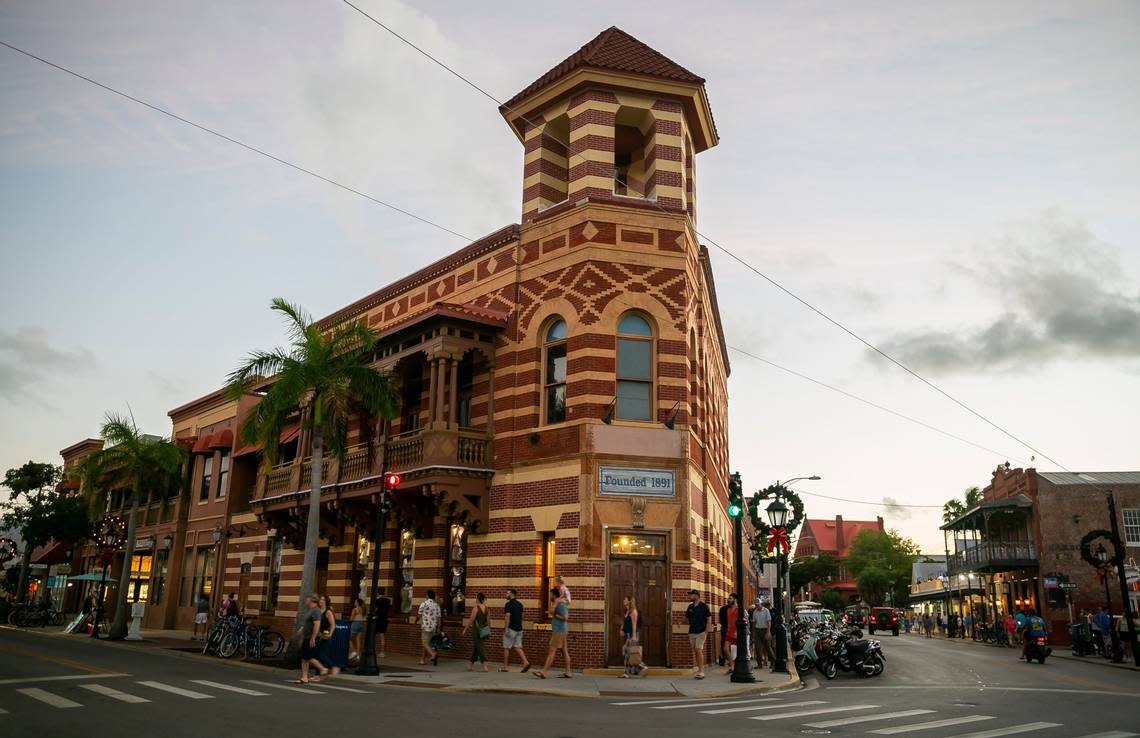 People make their way past Duval Street and Front Street in Key West, Florida on Saturday, December 11, 2021.