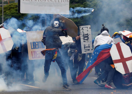 Opposition supporter throws a tear gas shell, during a clash with riot police, at a rally against President Nicolas Maduro in Caracas, Venezuela May 3, 2017. REUTERS/Carlos Garcia Rawlins