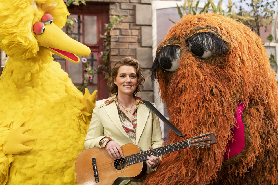 This image released by Sesame Workshop shows Brandi Carlile, center, with muppet characters Big Bird, left, and Mr. Snuffleupagus on the set of the children's show "Sesame Street." (Zach Hyman/Sesame Workshop via AP)