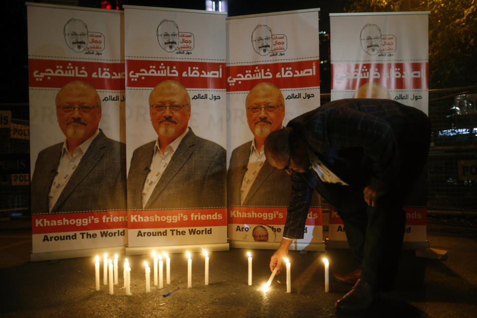 An activist lights a candle during a candlelight vigil for Saudi journalist Jamal Khashoggi outside Saudi Arabia's consulate in Istanbul, Thursday, Oct. 25, 2018. A group of Arab and international public, political and media figures are establishing a global association called "Khashoggi's Friends Around the World"; "to achieve justice for the freedom martyr".(AP Photo/Lefteris Pitarakis)