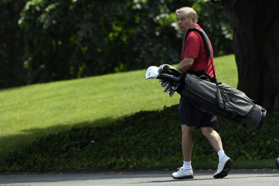 Senator Lindsey Graham, R-S.C., carries his golf clubs as he walks down the driveway of the White House in Washington, Sunday, June 16, 2019, after spending the day golfing with President Donald Trump. (AP Photo/Susan Walsh)