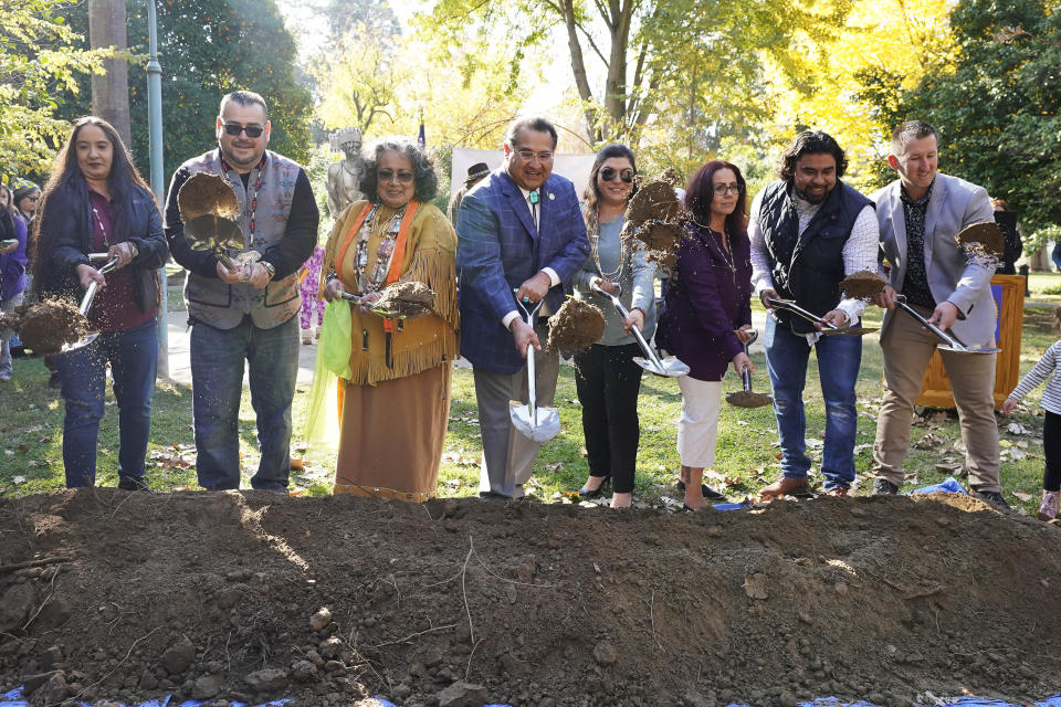Assemblyman James Ramos, D-Highlands, center, a resident of the San Manuel Band of Mission Indians and representatives of several Sacramento area tribes, shovel dirt in a groundbreaking ceremony for a Native American monument at Capitol Park in Sacramento, Calif., Monday, Nov. 14, 2022. (AP Photo/Rich Pedroncelli