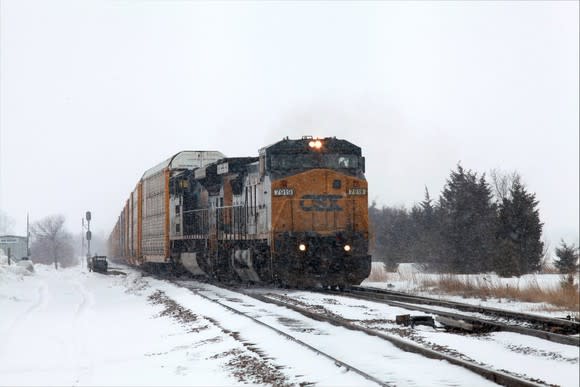A CSX train traversing a snowy landscape.