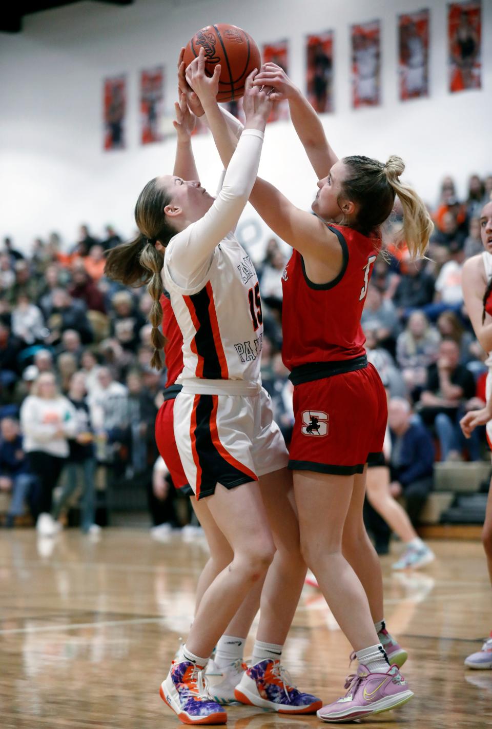 New Lexington's Chloe Dick, left, fights for a rebound with Sheridan's Ava Heller during the third quarter on Wednesday night  in New Lex. Sheridan won, 56-50, despite Dick's team-high 15 points.