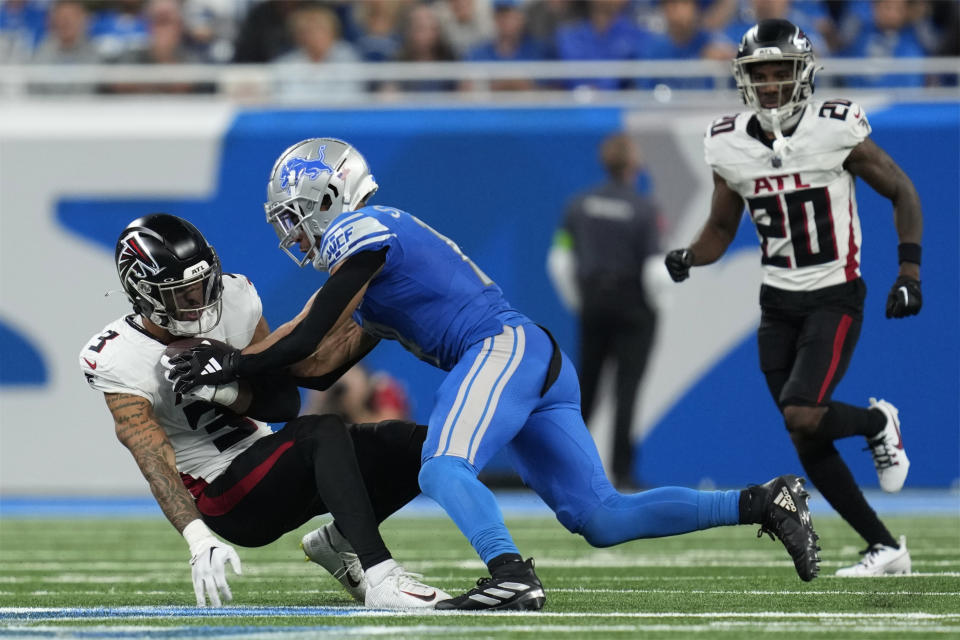 Atlanta Falcons safety Jessie Bates III (3) intercepts a pass intended for Detroit Lions wide receiver Amon-Ra St. Brown, center, in the second half of an NFL football game Sunday, Sept. 24, 2023, in Detroit. (AP Photo/Paul Sancya)