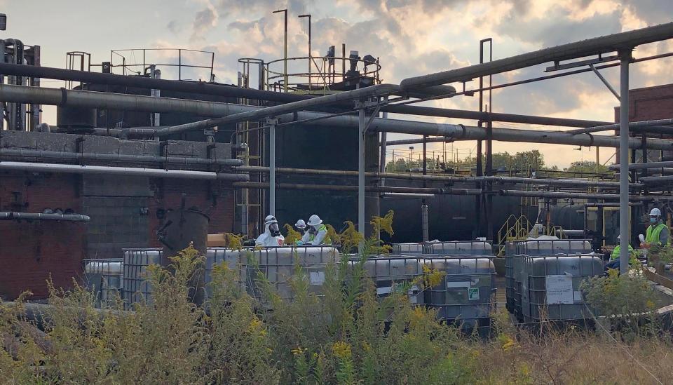 Workers contracted by the Environmental Protection Agency take samples from totes left at the former Erie Coke Corp. site on Oct. 10, 2020. The EPA is overseeing a clean-up of the site.