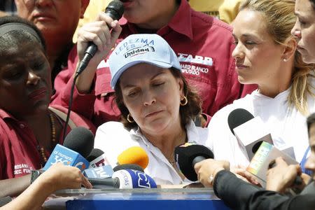 Mitzy de Ledezma (C), wife of arrested Caracas metropolitan mayor Antonio Ledezma, reacts next to Lilian Tintori (2nd R), wife of jailed opposition leader Leopoldo Lopez, and opposition leader Maria Corina Machado (R), during a gathering in support of Ledezma, in Caracas Febreuary 20, 2015. REUTERS/Carlos Garcia Rawlins