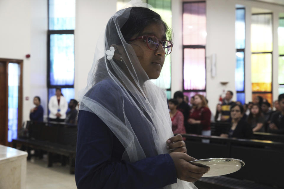 In this Sunday, Jan. 20, 2019 photo, a young girl holds a communion plate during Mass at St. Mary's Catholic Church in Dubai, United Arab Emirates. Pope Francis’ visit from Feb. 3 through Feb. 5 marks the first papal visit in history to the Arabian Peninsula, the birthplace of Islam. A diverse and international flock awaits him. The Catholic Church believes there are some 1 million Catholics in the UAE today. (AP Photo/Jon Gambrell)