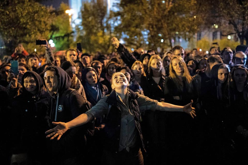 A young woman dances under the rain during a protest against construction of a cathedral in Yekaterinburg, Russia, Thursday, May 16, 2019. Russian police detained several dozen people in the early hours on Thursday at a rally protesting plans to build a cathedral in a popular park in Russia's fourth-largest city. (AP Photo/Evgeny Feldman)