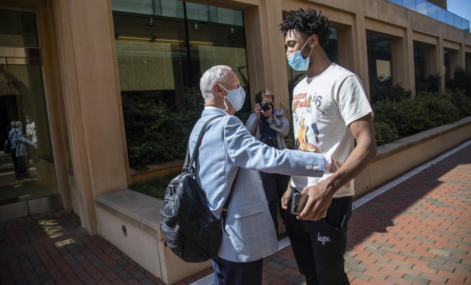 North Carolina basketball player Leaky Black greets head coach Roy Williams at the Dean Smith Center on campus prior to an NCAA college basketball news conference, Thursday, April 1, 2021, in Chapel Hill, N.C. Williams announced his retirement. (Travis Long/The News & Observer via AP)