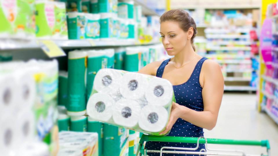 woman buys toilet paper in the supermarket.