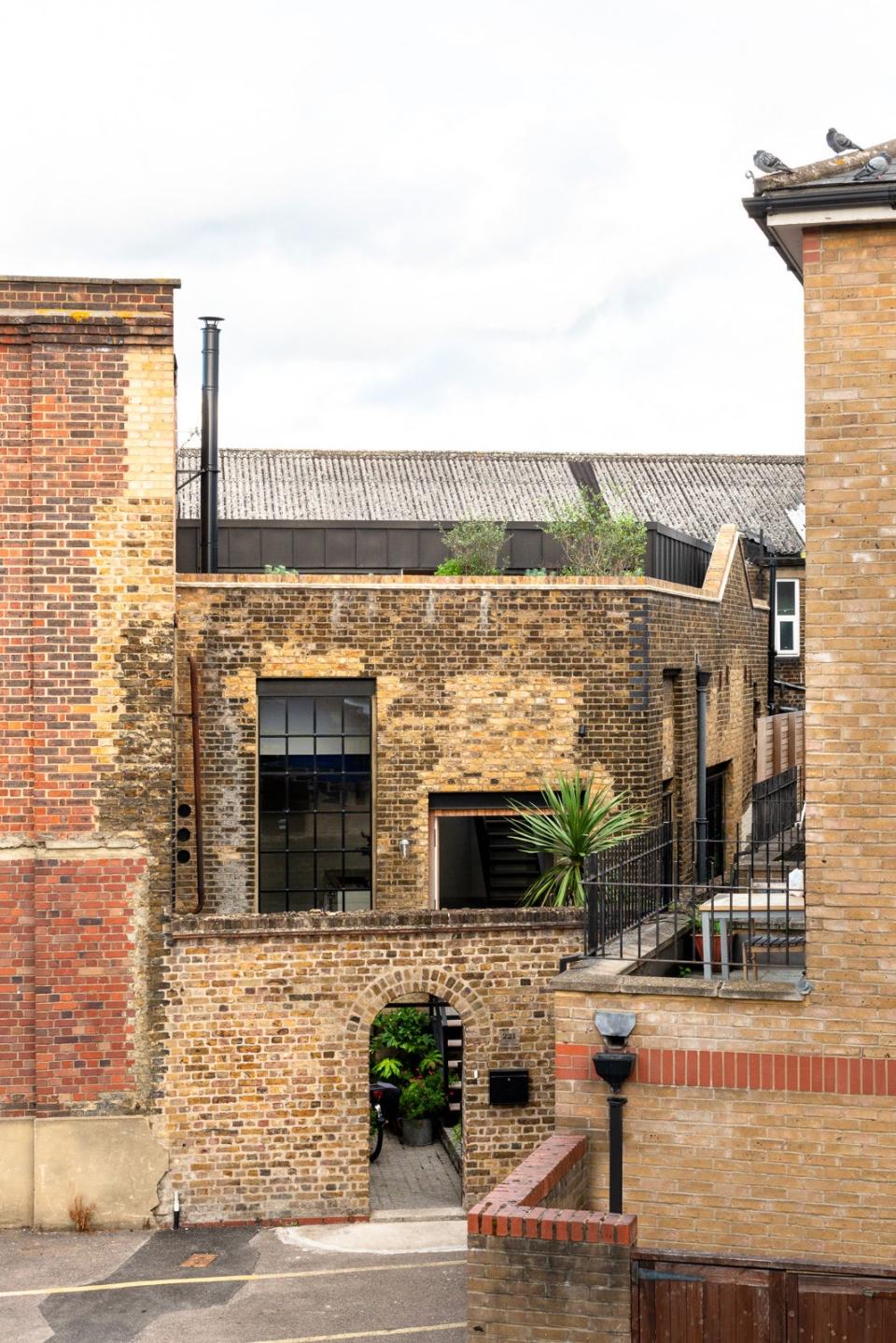 The unassuming aged brick exterior is brightened with pops of greenery.