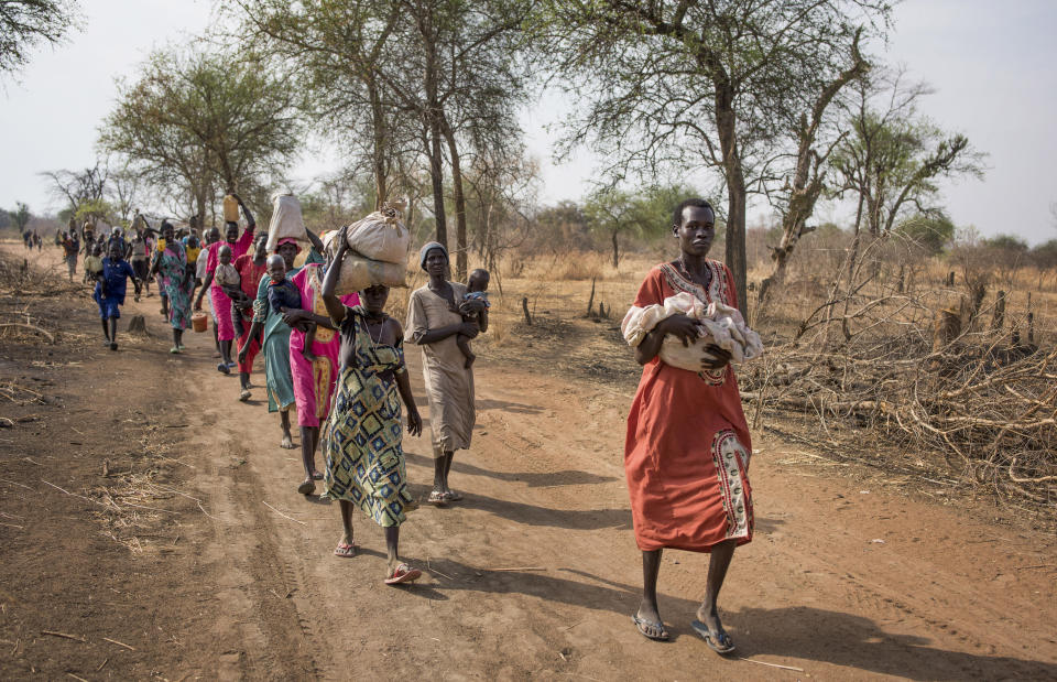 FILE - In this Wednesday, April 5, 2017 file photo, people walk to reach a food distribution site in Malualkuel, the Northern Bahr el Ghazal region of South Sudan. Five months into South Sudan's fragile peace, 1.5 million people are on the brink of starvation and half the population, more than six million people, are facing extreme hunger, say the United Nations and South Sudan's government in a report issued Friday, Feb. 22, 2019. (AP Photo, File)