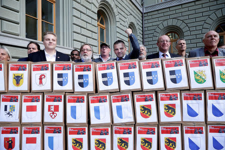 Walter Wobmann (5-R), National Councillor and Co-President committee for "Yes to a Mask Ban" (Ja zum Verhuellungsverbot), and members hand over boxes containing more than 100,000 signatures collected that are required to put the proposal of a ban on facial coverings worn by some Muslim women to a national vote, at the Federal Chancellery in Bern, Switzerland September 15, 2017. REUTERS/Moritz Hager