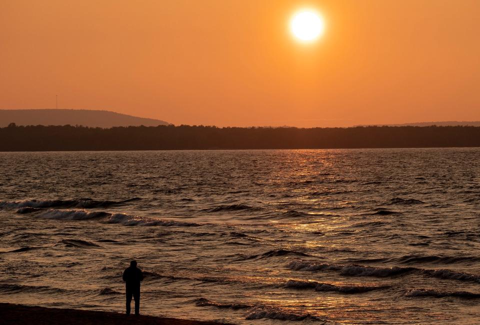 The beach at AuTrain is a popular place to view the sunset over Lake Superior. It is especially nice when a long lens is used to compress the image which makes the sun look bigger.