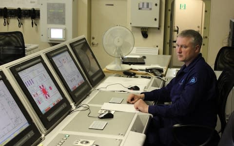 A crew member monitors the reactors in the floating plant's control room - Credit: Alec Luhn/For The Telegraph