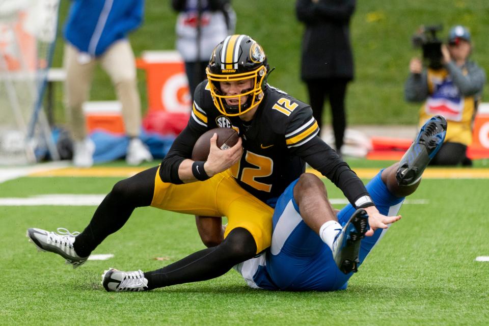 Missouri quarterback Brady Cook (12) is sacked by Kentucky's Trevin Wallace during the second quarter of an NCAA college football game Saturday, Nov. 5, 2022, in Columbia, Mo. (AP Photo/L.G. Patterson)