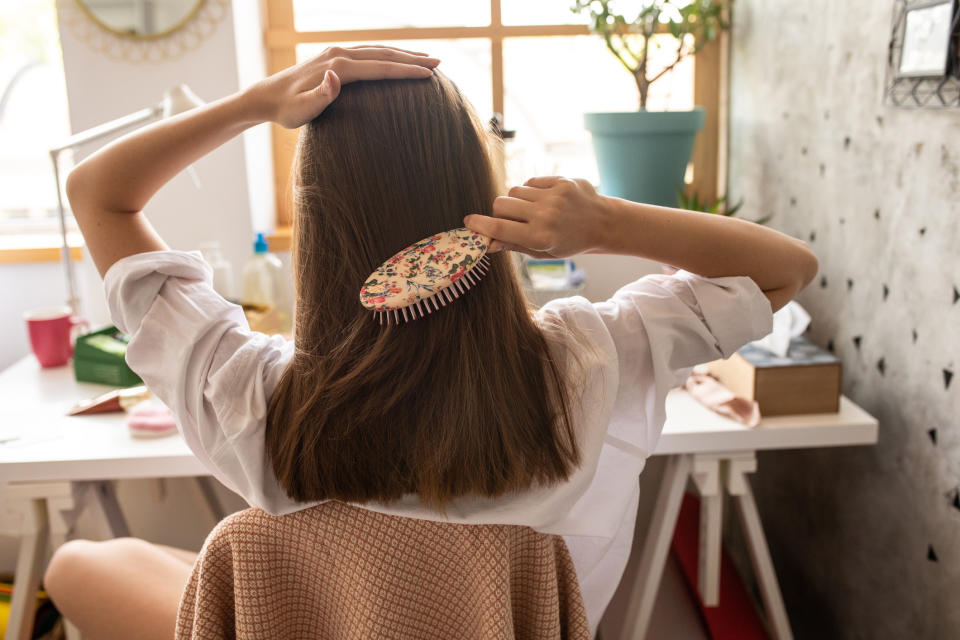 A woman is brushing her hair