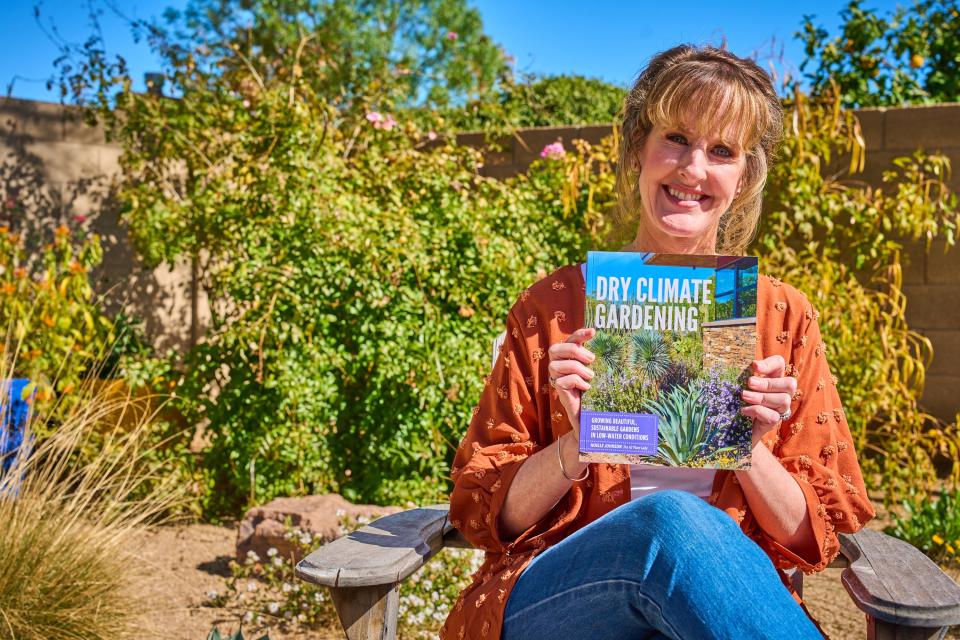 Noelle Johnson, aka AZ Plant Lady, poses for a portrait with her new book "Dry Climate Gardening" in her back garden on Feb. 20, 2023.