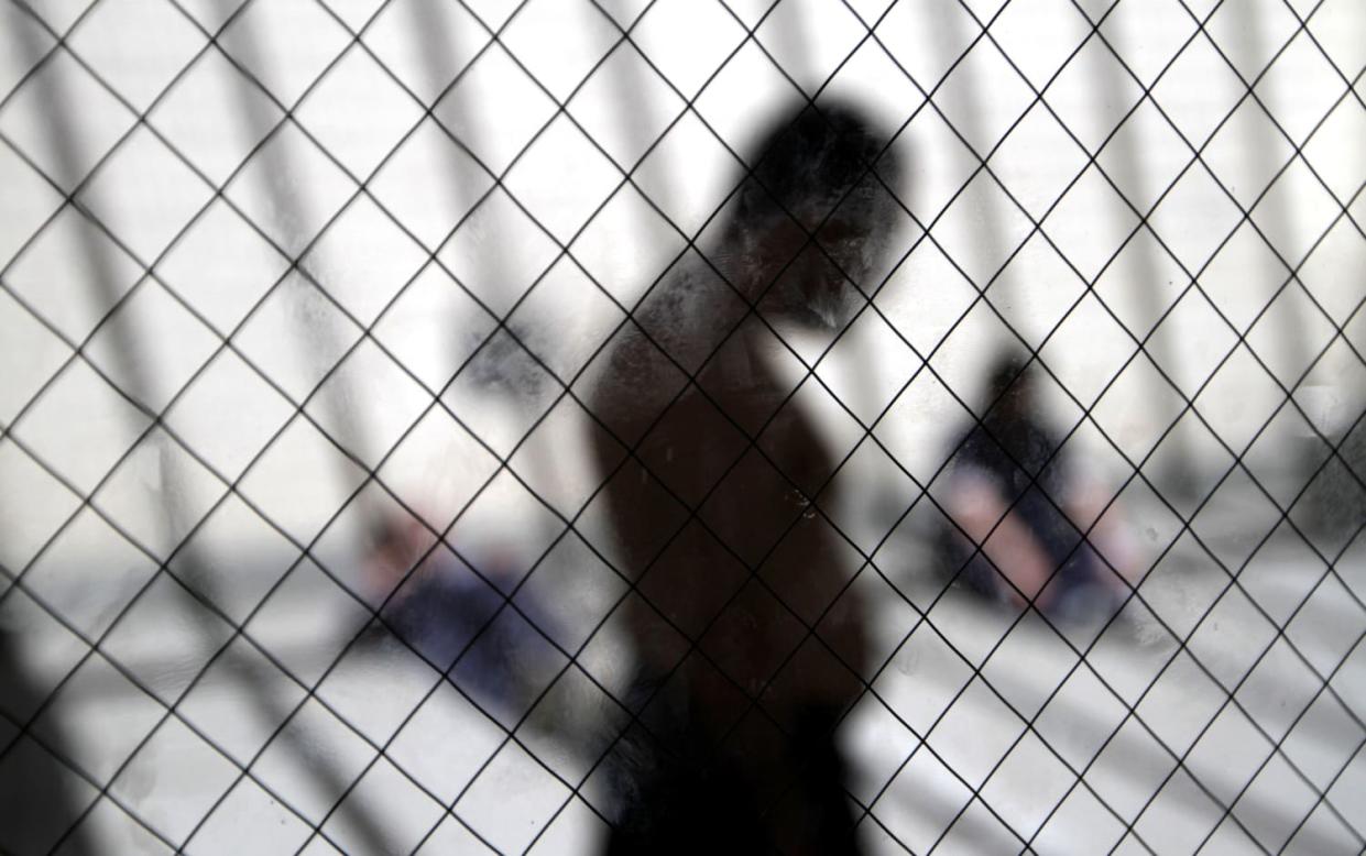 Image: Men sit in the sun at the Otay Mesa Detention Center in San Diego, California, on May 26, 2010.