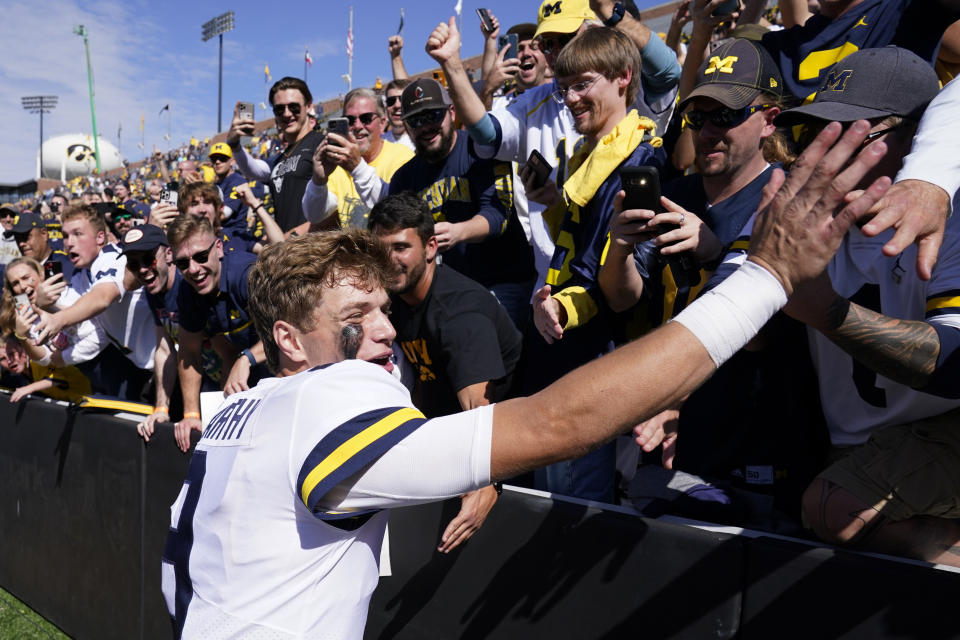 FILE - Michigan quarterback J.J. McCarthy (9) celebrates with fans after an NCAA college football game against Iowa, Saturday, Oct. 1, 2022, in Iowa City, Iowa. Michigan won 27-14. Michigan is No. 2 in The Associated Press preseason Top 25 poll released Monday, Aug. 14, 2023. (AP Photo/Charlie Neibergall, File)